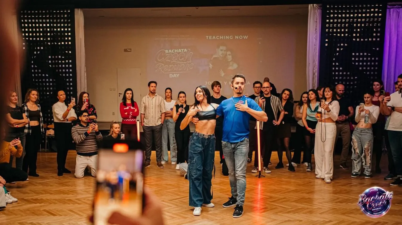 An instructor couple demonstrating a bachata move to a circle of dancers at a Bachata Czech Republic event
