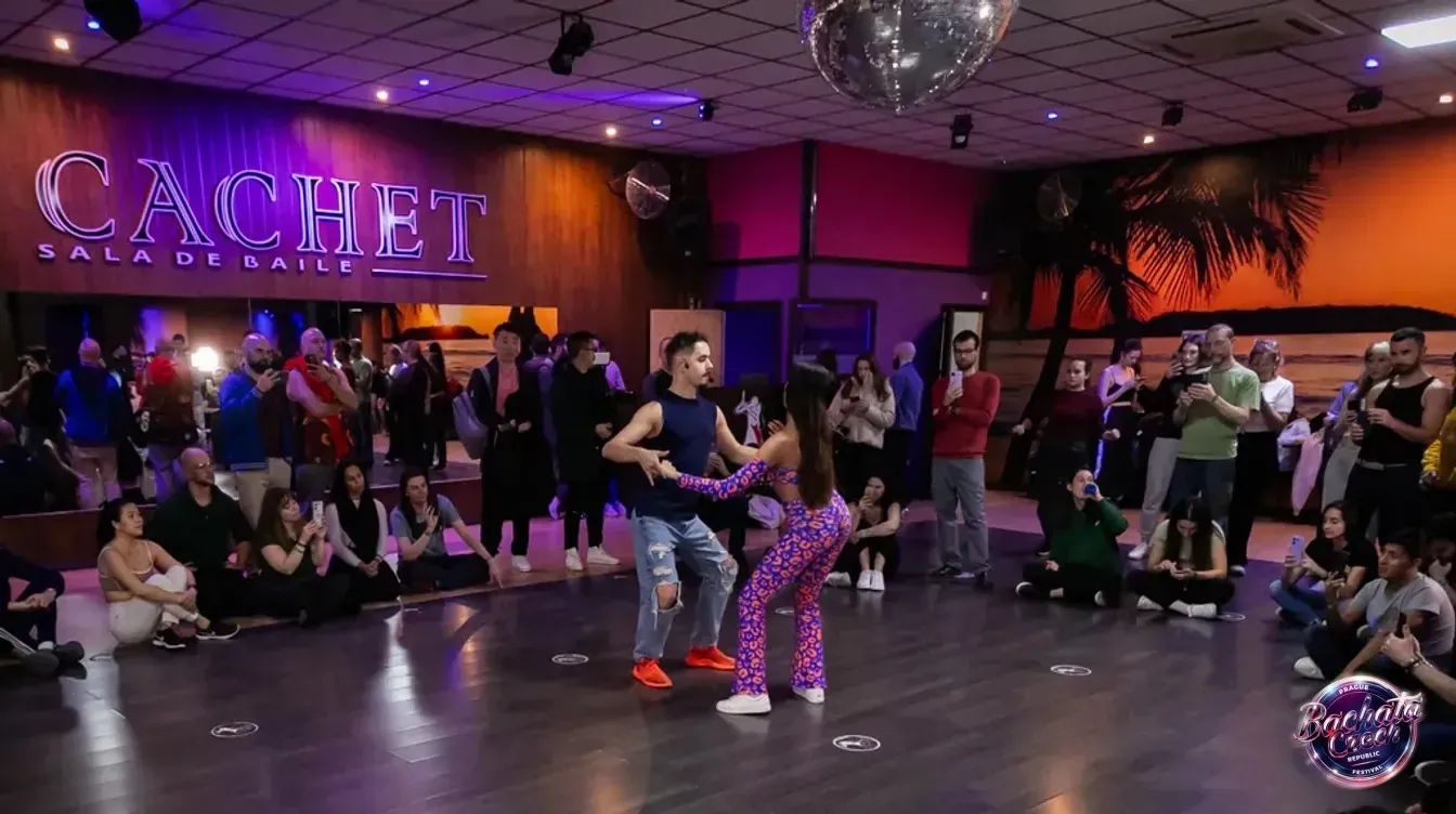 Jorge and Mónica dancing bachata in the middle of a circle of dancers at a dance hall in Spain