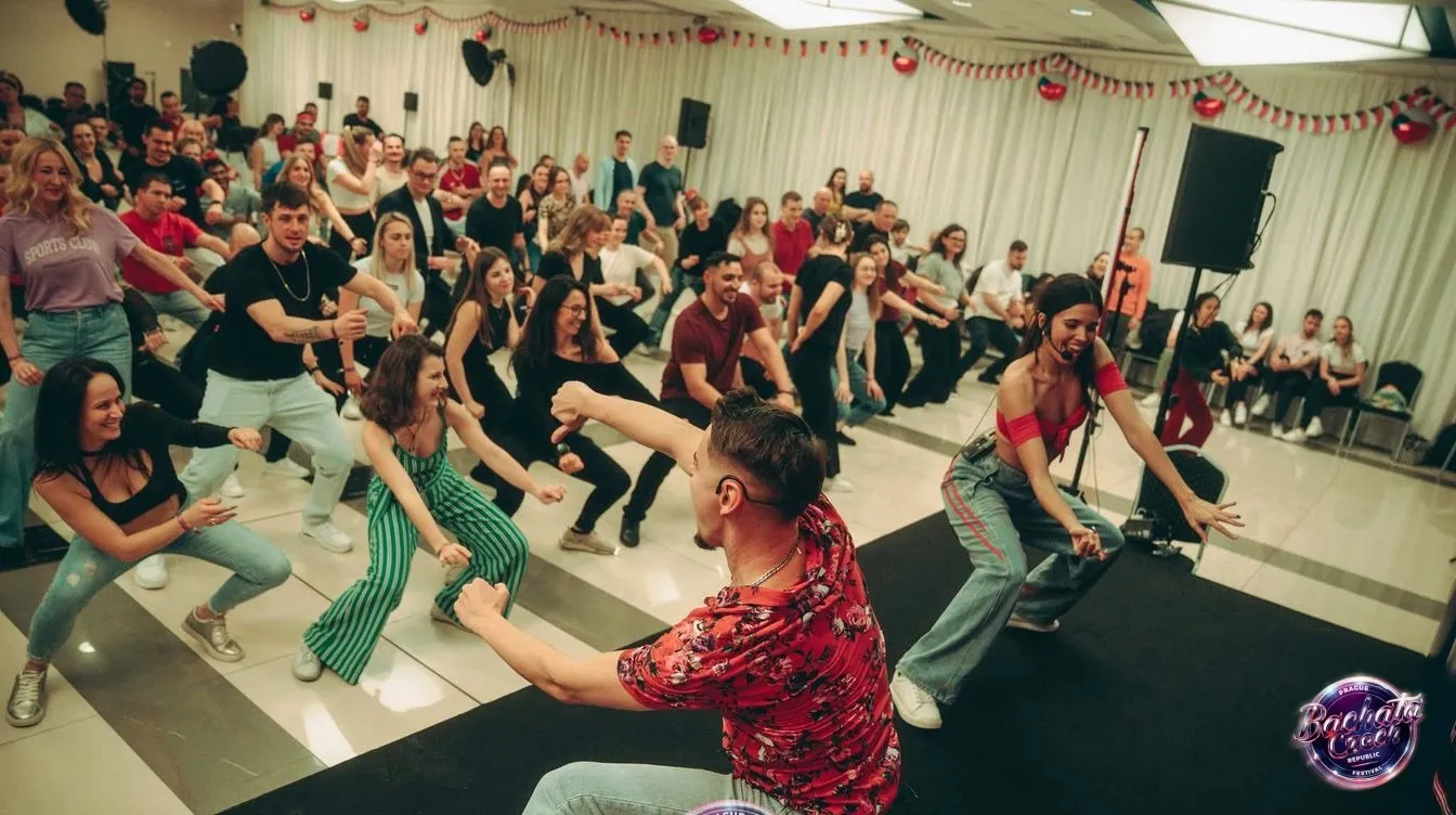 A packed bachata class in Prague with dancers following an instructor's footwork